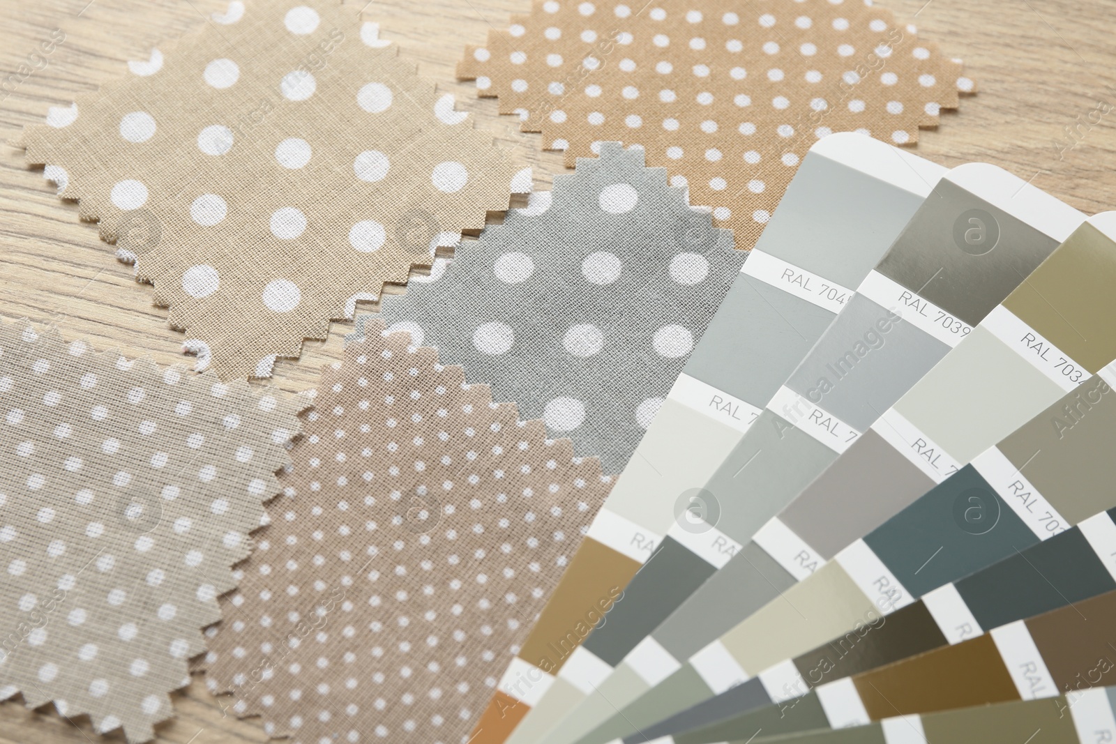 Samples of colorful fabrics and color palettes on wooden table, closeup Photo of Samples of colorful fabrics and color palettes on wooden table, closeup
