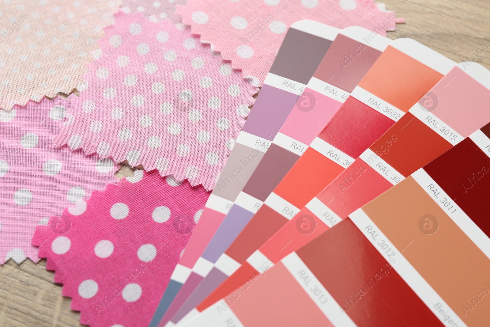 Samples of colorful fabrics and color palettes on wooden table, closeup Photo of Samples of colorful fabrics and color palettes on wooden table, closeup