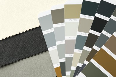Photo of Samples of colorful fabrics and color palettes, top view