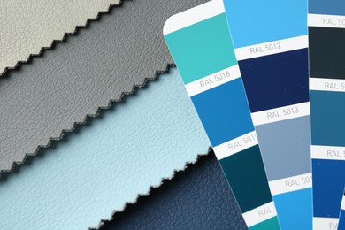 Photo of Samples of colorful fabrics and color palettes, above view