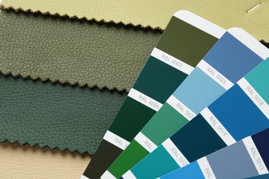Photo of Samples of colorful fabrics and color palettes, top view