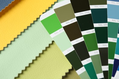 Photo of Samples of colorful fabrics and color palettes, closeup