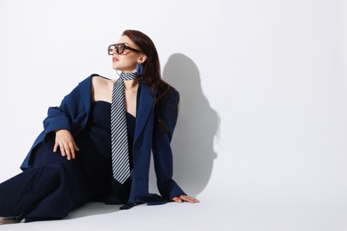 Photo of Young woman in stylish clothes on white background, space for text