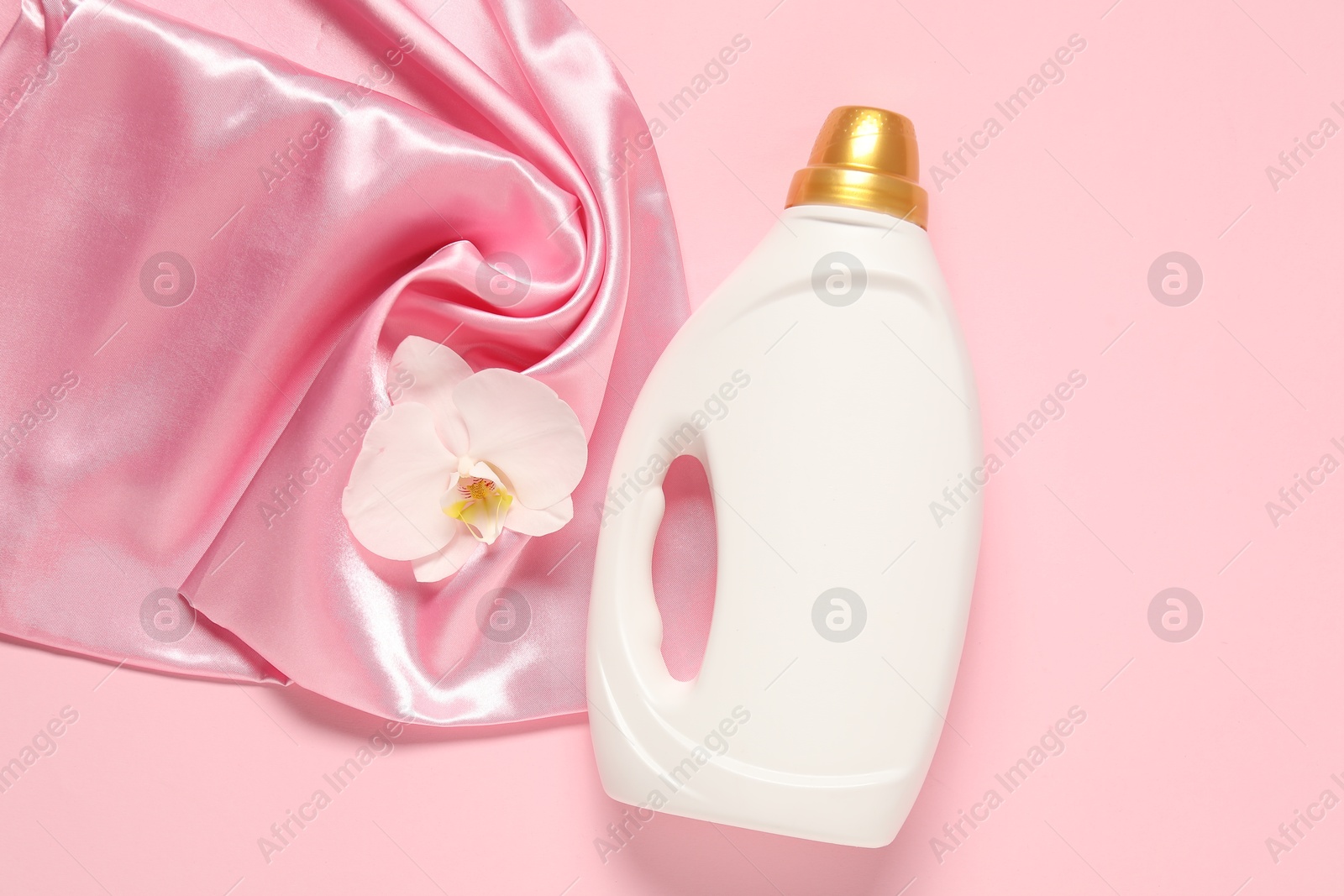 Bottle of fabric softener, orchid flower and color cloth on pink background, flat lay Photo of Bottle of fabric softener, orchid flower and color cloth on pink background, flat lay