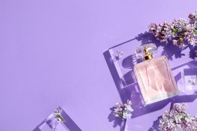 Photo of Flat lay composition with bottle of perfume and lilac flowers on violet background. Space for text