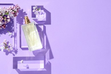 Photo of Flat lay composition with bottle of perfume and lilac flowers on violet background. Space for text