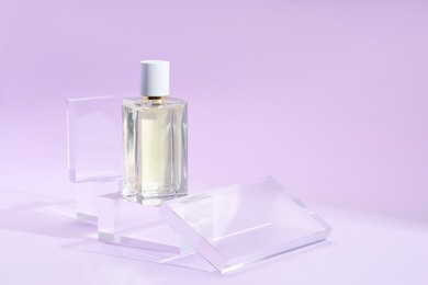 Photo of Stylish presentation of perfume bottle on violet background, closeup