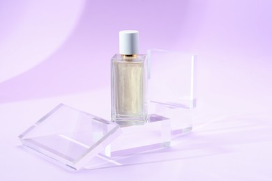 Photo of Stylish presentation of perfume bottle on violet background, closeup