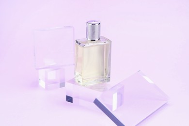Photo of Stylish presentation of perfume bottle on violet background, closeup