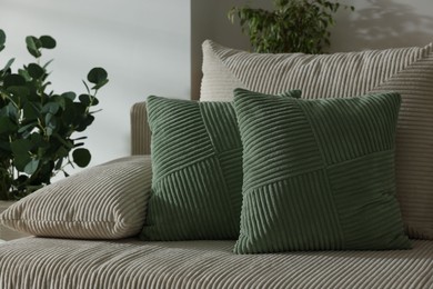 Photo of Two light green cushions on sofa indoors
