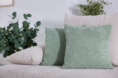 Photo of Two light green cushions on sofa indoors