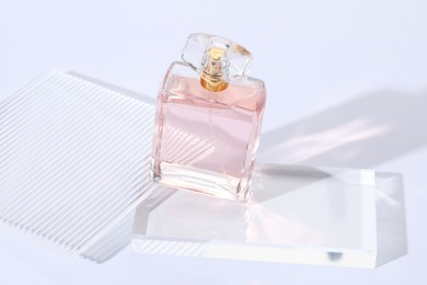 Photo of Stylish presentation of perfume bottle on light background, closeup