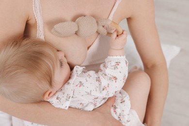 Photo of Mother breastfeeding her cute little baby indoors, closeup