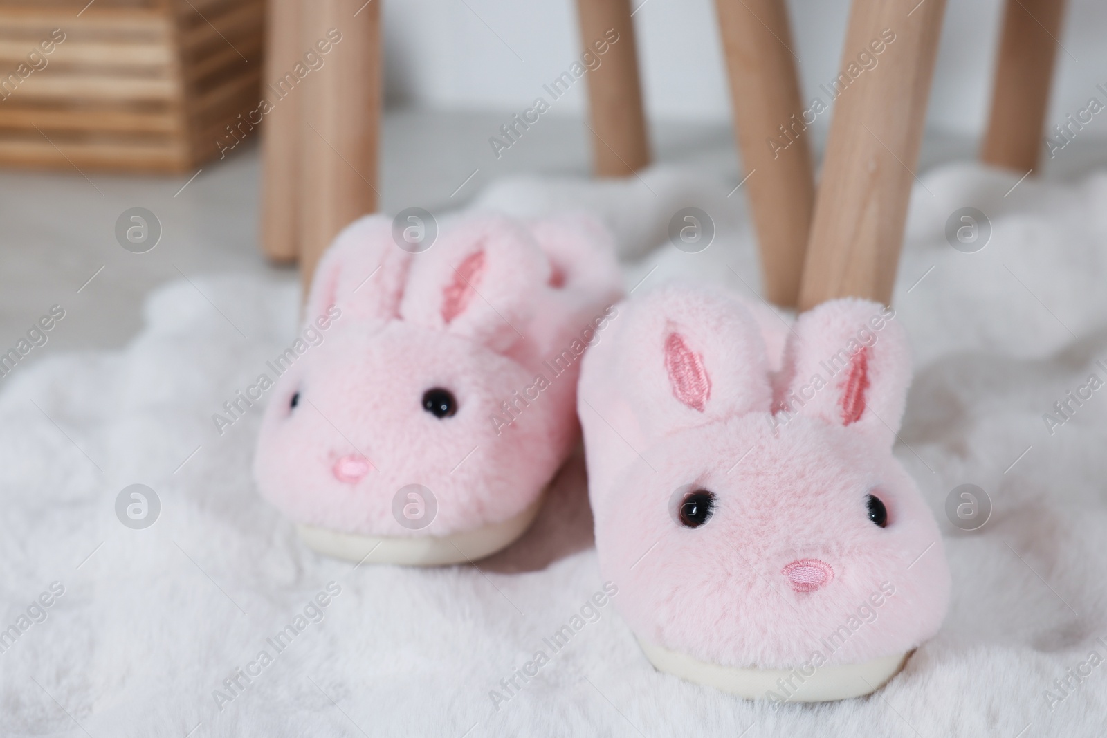 Cute kid slippers in shape of bunnies on floor indoors Photo of Cute kid slippers in shape of bunnies on floor indoors