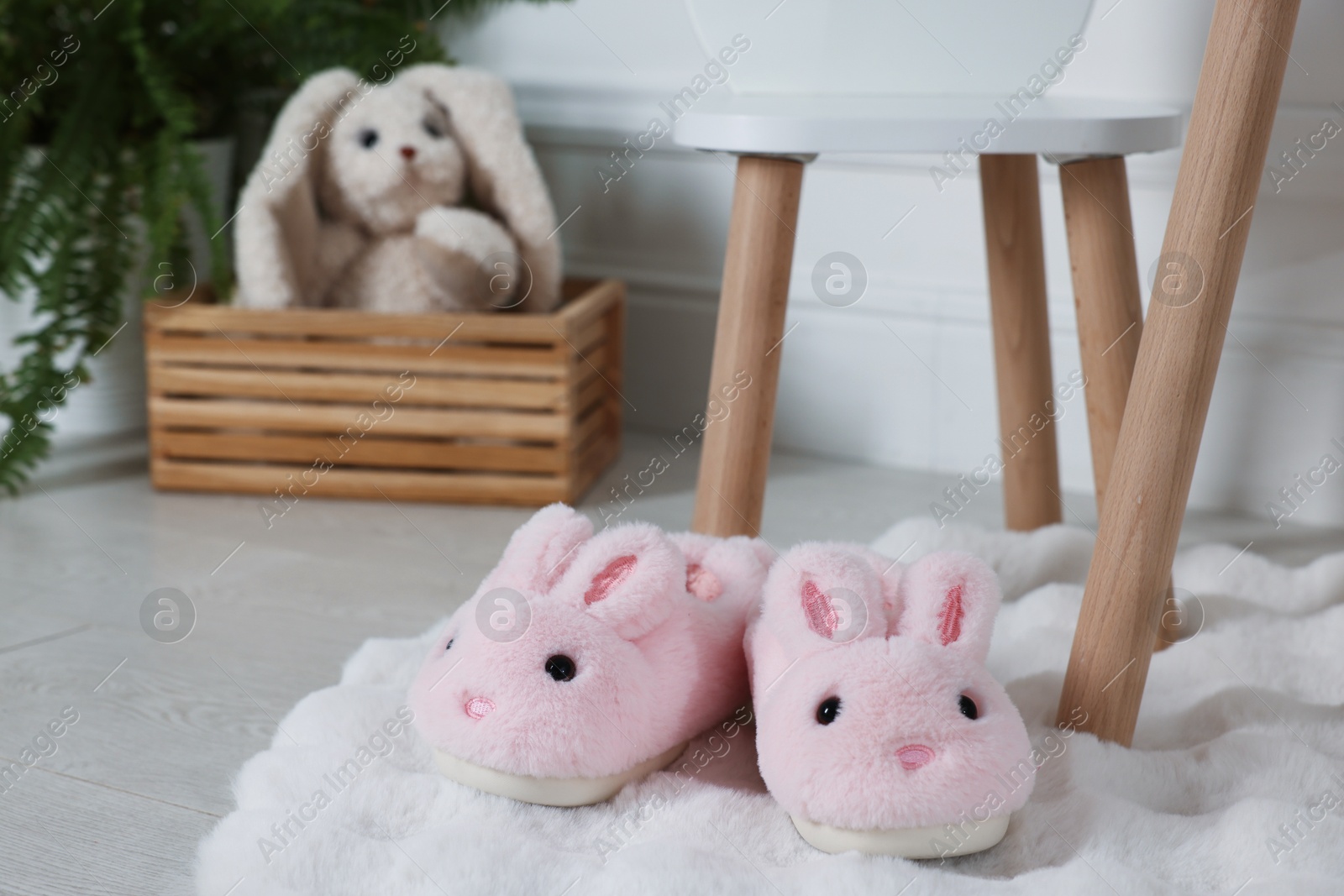 Cute kid slippers in shape of bunnies on floor indoors Photo of Cute kid slippers in shape of bunnies on floor indoors