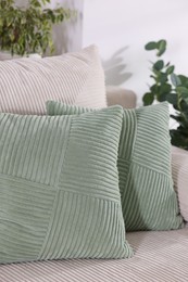 Photo of Two light green cushions on sofa indoors