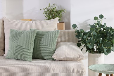 Photo of Two light green cushions on sofa indoors