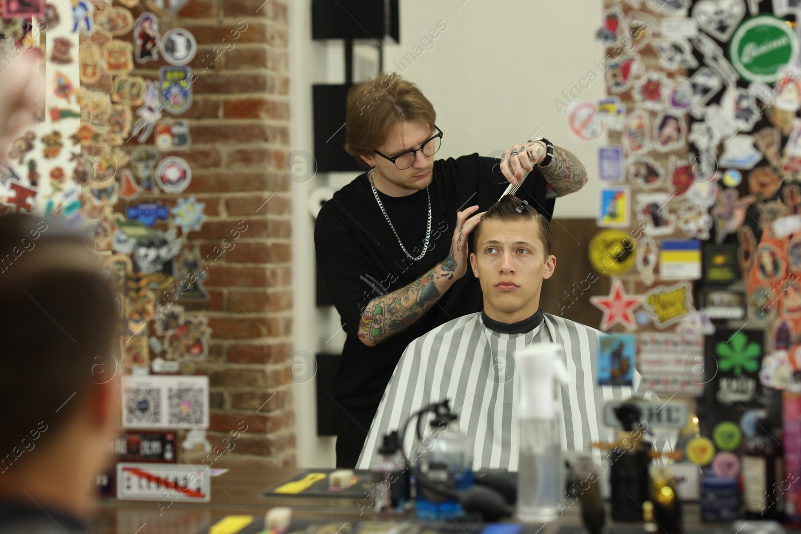 Professional barber working with client in barbershop Photo of Professional barber working with client in barbershop