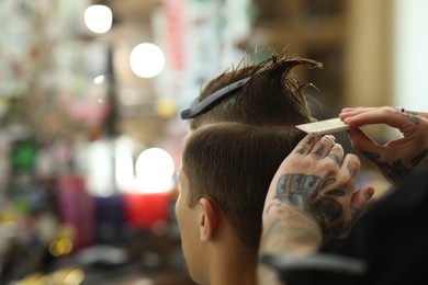 Photo of Professional barber working with client in barbershop, closeup. Space for text
