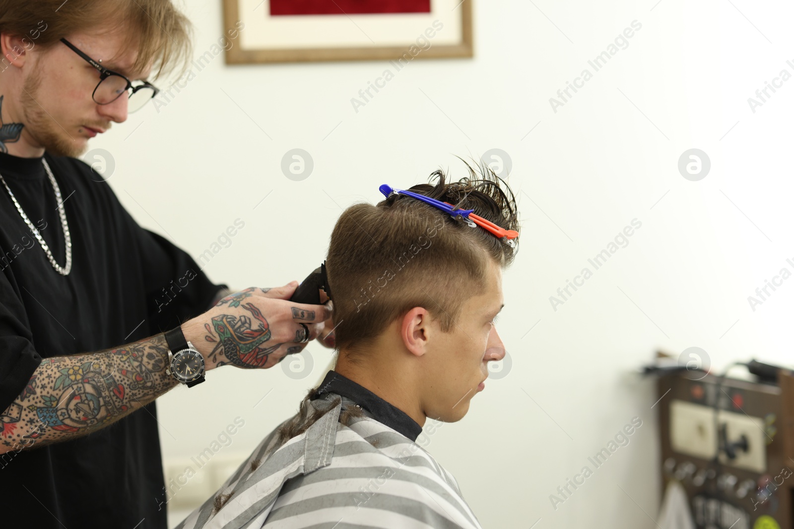 Professional barber making stylish haircut in barbershop Photo of Professional barber making stylish haircut in barbershop