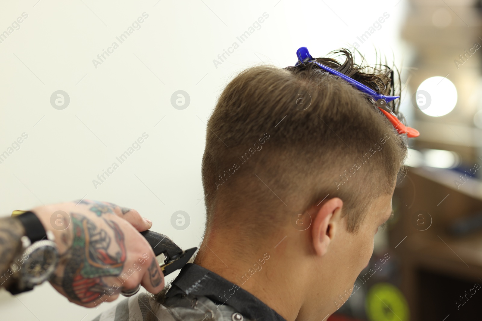 Professional barber making stylish haircut in barbershop, closeup Photo of Professional barber making stylish haircut in barbershop, closeup