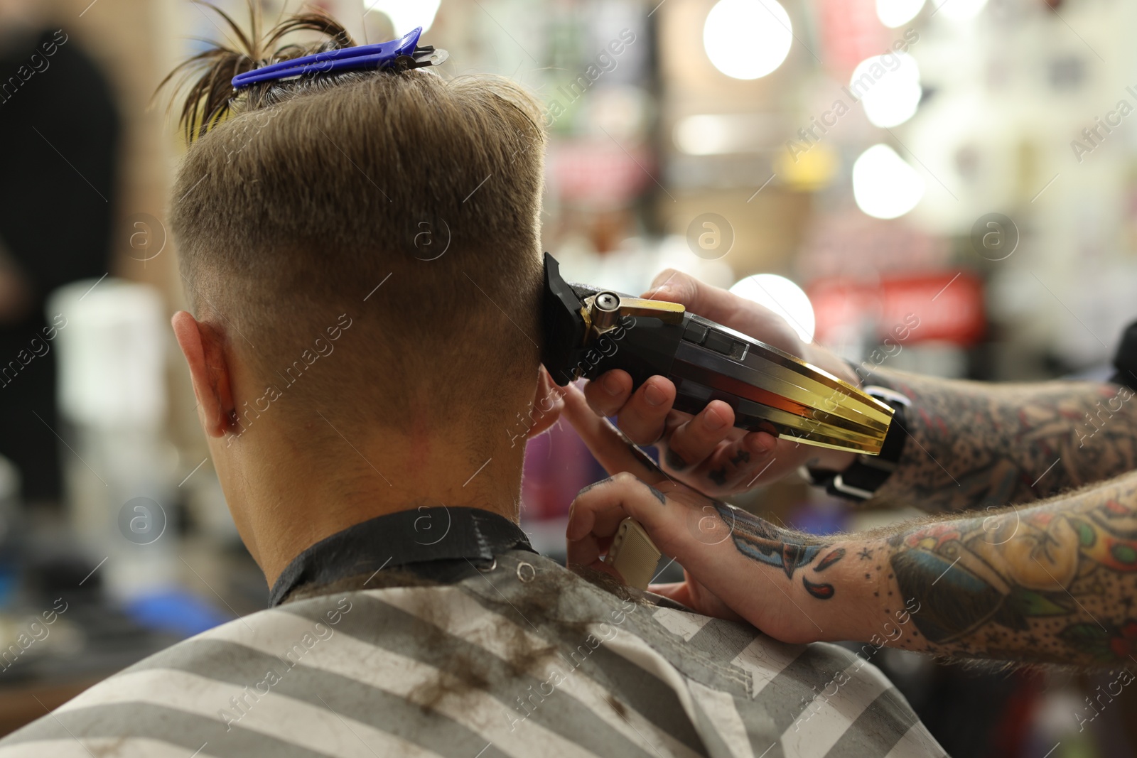 Professional barber making stylish haircut in barbershop, closeup Photo of Professional barber making stylish haircut in barbershop, closeup