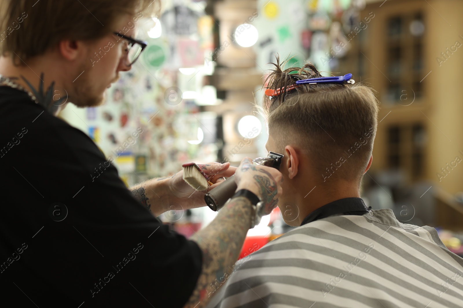 Professional barber making stylish haircut in barbershop Photo of Professional barber making stylish haircut in barbershop