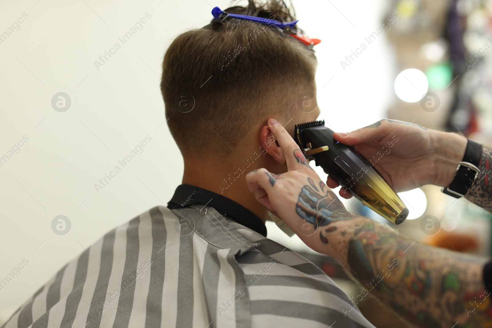Professional barber making stylish haircut in barbershop, closeup Photo of Professional barber making stylish haircut in barbershop, closeup