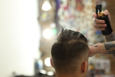 Photo of Professional barber making stylish haircut in barbershop, closeup. Space for text