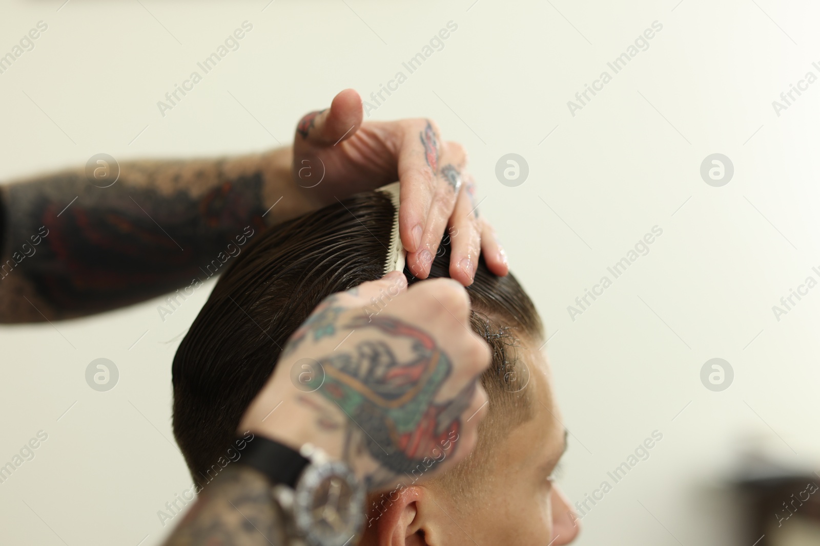 Professional barber making stylish haircut in barbershop, closeup Photo of Professional barber making stylish haircut in barbershop, closeup