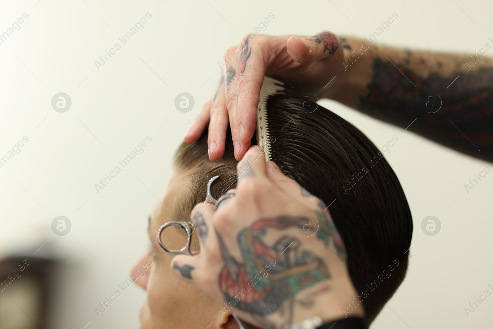 Professional barber making stylish haircut in barbershop, closeup Photo of Professional barber making stylish haircut in barbershop, closeup