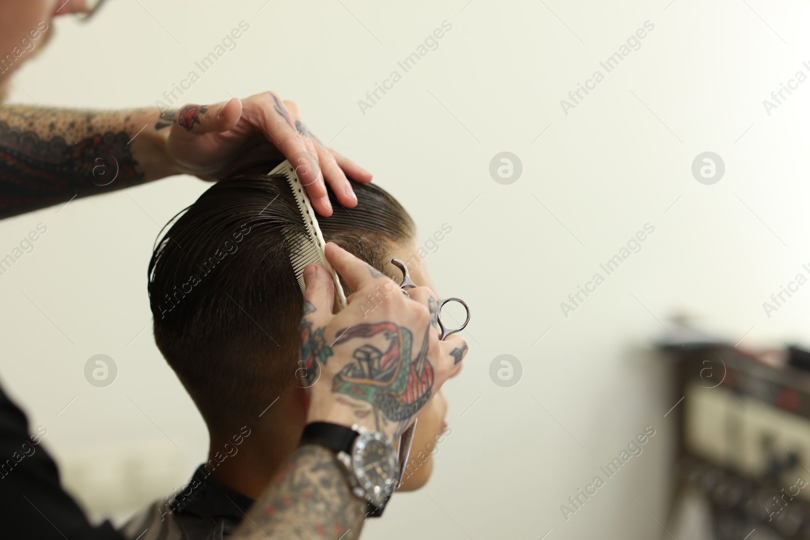 Professional barber making stylish haircut in barbershop, closeup. Space for text Photo of Professional barber making stylish haircut in barbershop, closeup. Space for text