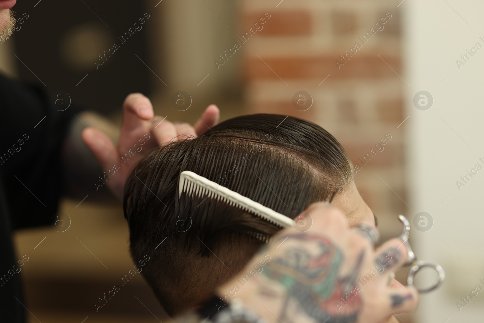Professional barber making stylish haircut in barbershop, closeup Photo of Professional barber making stylish haircut in barbershop, closeup