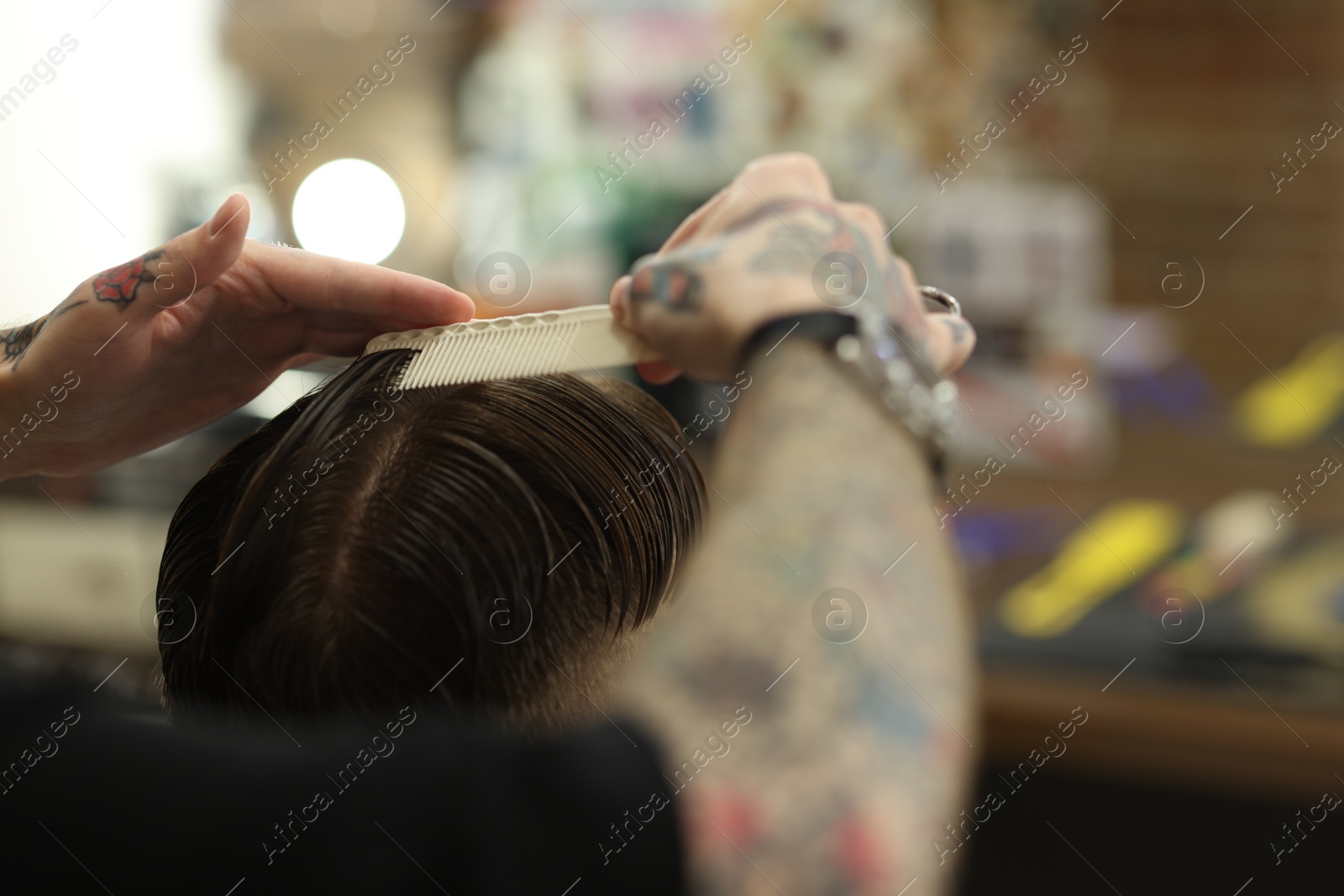 Professional barber making stylish haircut in barbershop, closeup Photo of Professional barber making stylish haircut in barbershop, closeup