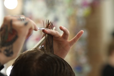 Photo of Professional barber cutting client's hair with scissors in barbershop, closeup. Space for text