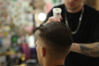 Photo of Professional barber making stylish haircut in barbershop, closeup. Space for text