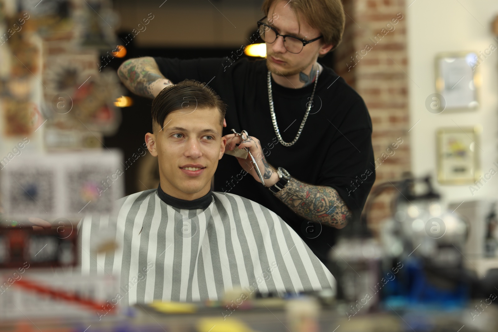 Professional barber making stylish haircut in barbershop Photo of Professional barber making stylish haircut in barbershop