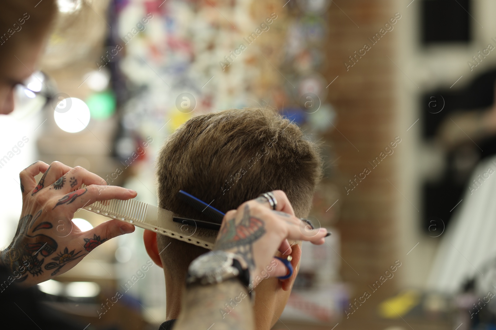 Professional barber cutting client's hair with scissors in barbershop, closeup. Space for text Photo of Professional barber cutting client's hair with scissors in barbershop, closeup. Space for text