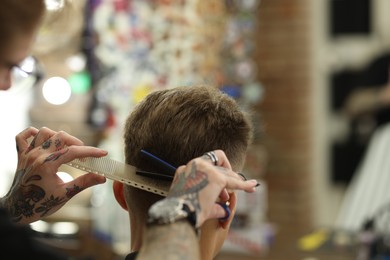 Photo of Professional barber cutting client's hair with scissors in barbershop, closeup. Space for text