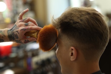 Photo of Professional barber working with client in barbershop, closeup