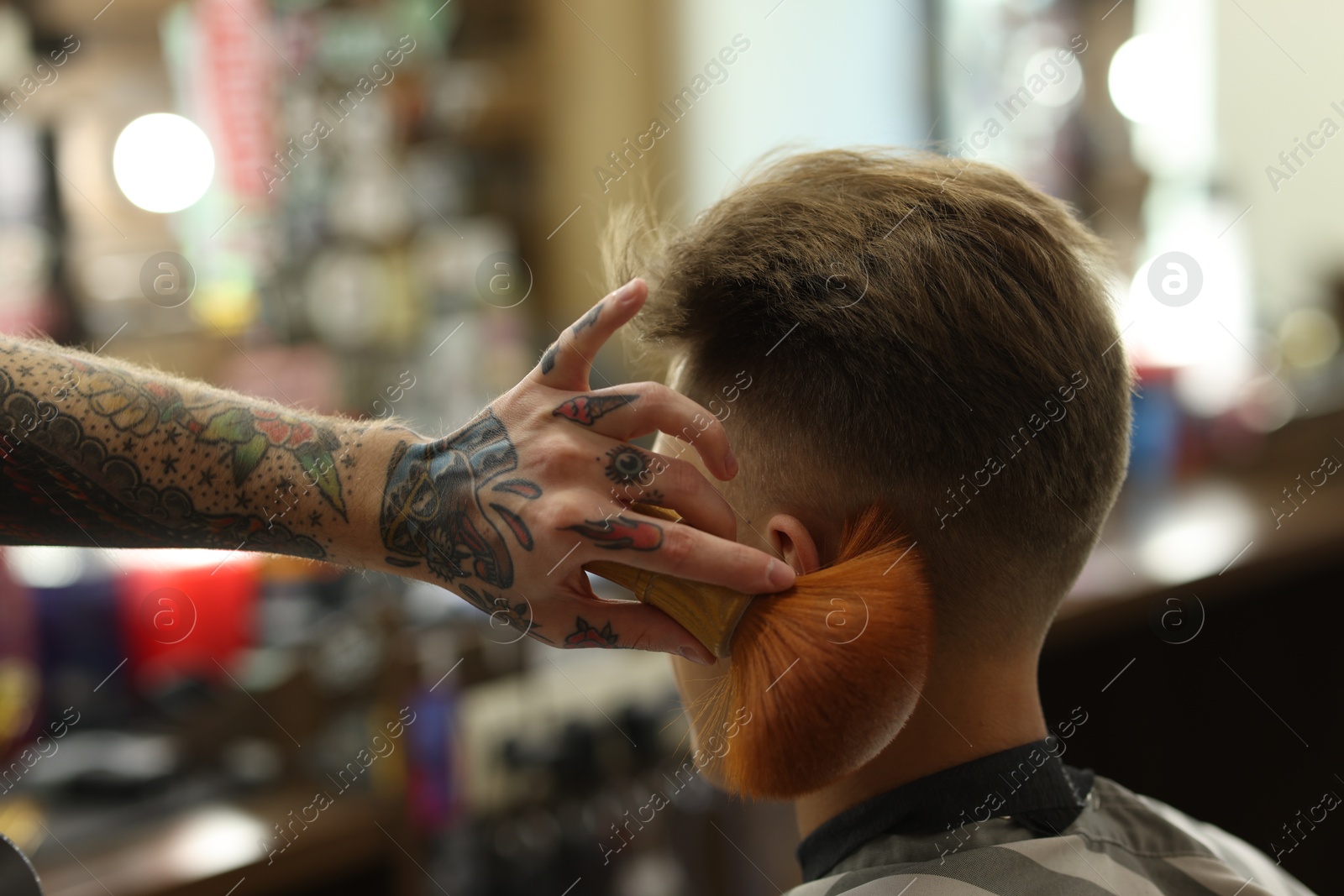 Professional barber working with client in barbershop, closeup Photo of Professional barber working with client in barbershop, closeup