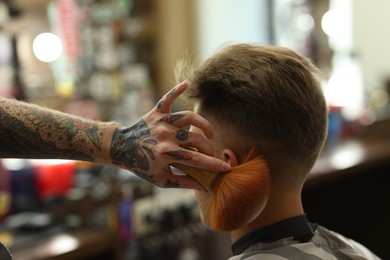 Photo of Professional barber working with client in barbershop, closeup