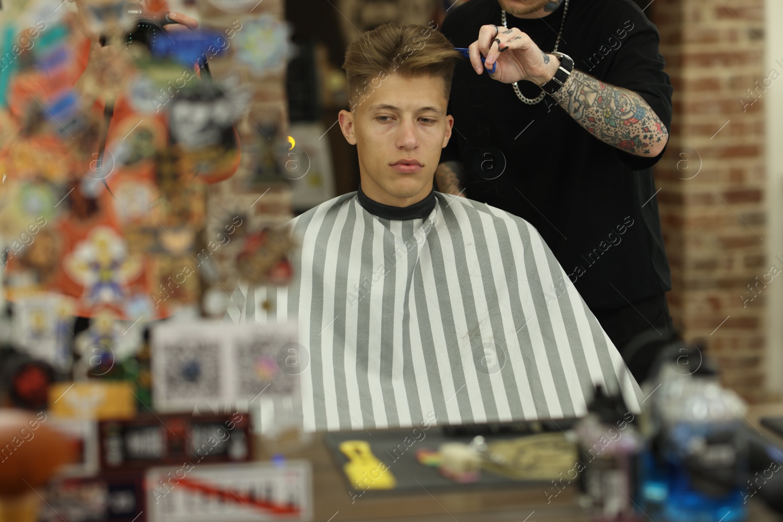 Professional barber cutting client's hair with scissors in barbershop, closeup Photo of Professional barber cutting client's hair with scissors in barbershop, closeup