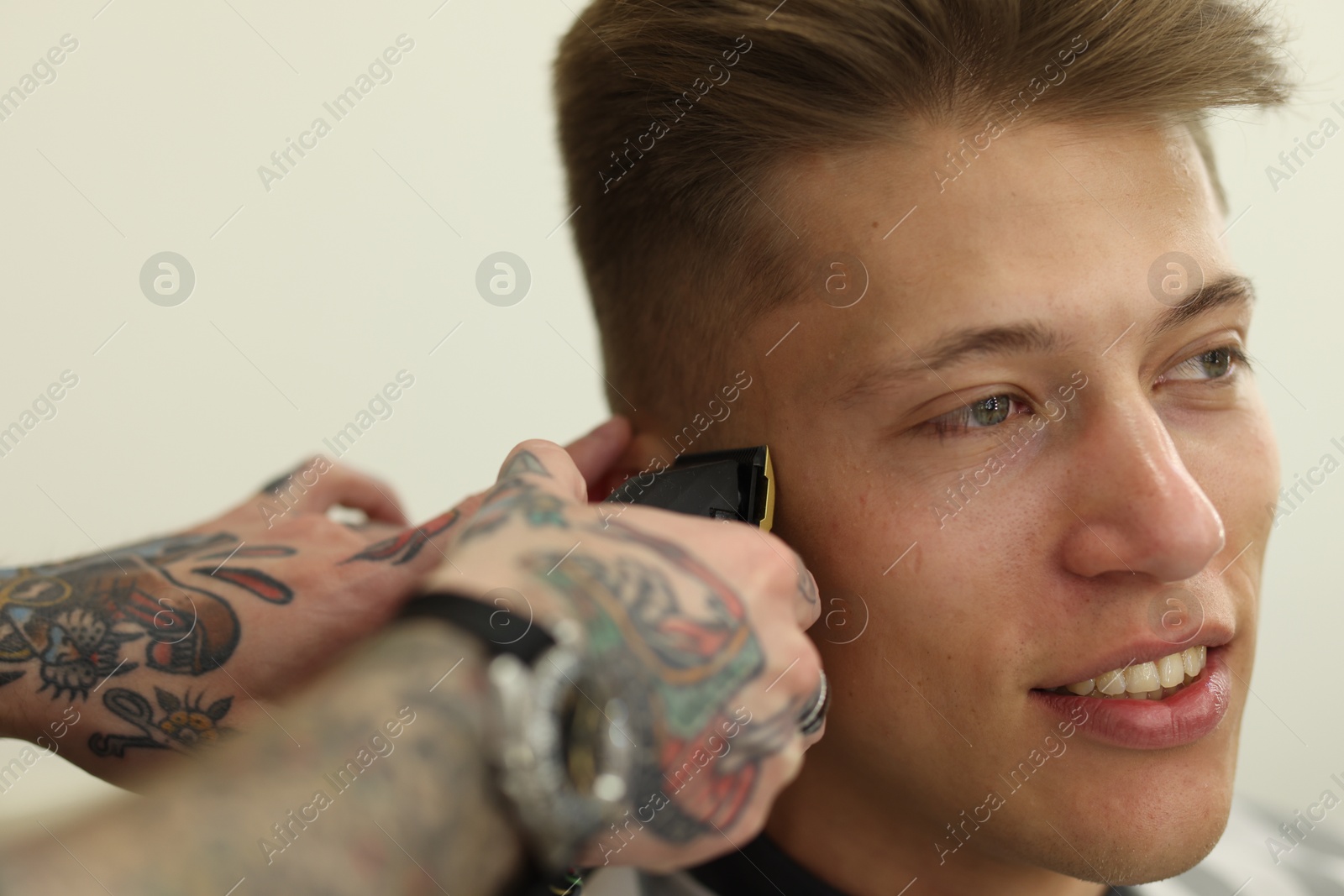 Professional barber making stylish haircut in barbershop, closeup Photo of Professional barber making stylish haircut in barbershop, closeup
