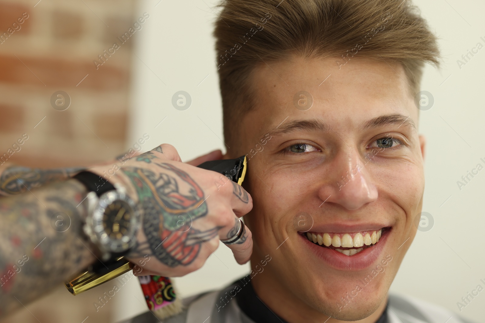 Professional barber making stylish haircut in barbershop, closeup Photo of Professional barber making stylish haircut in barbershop, closeup