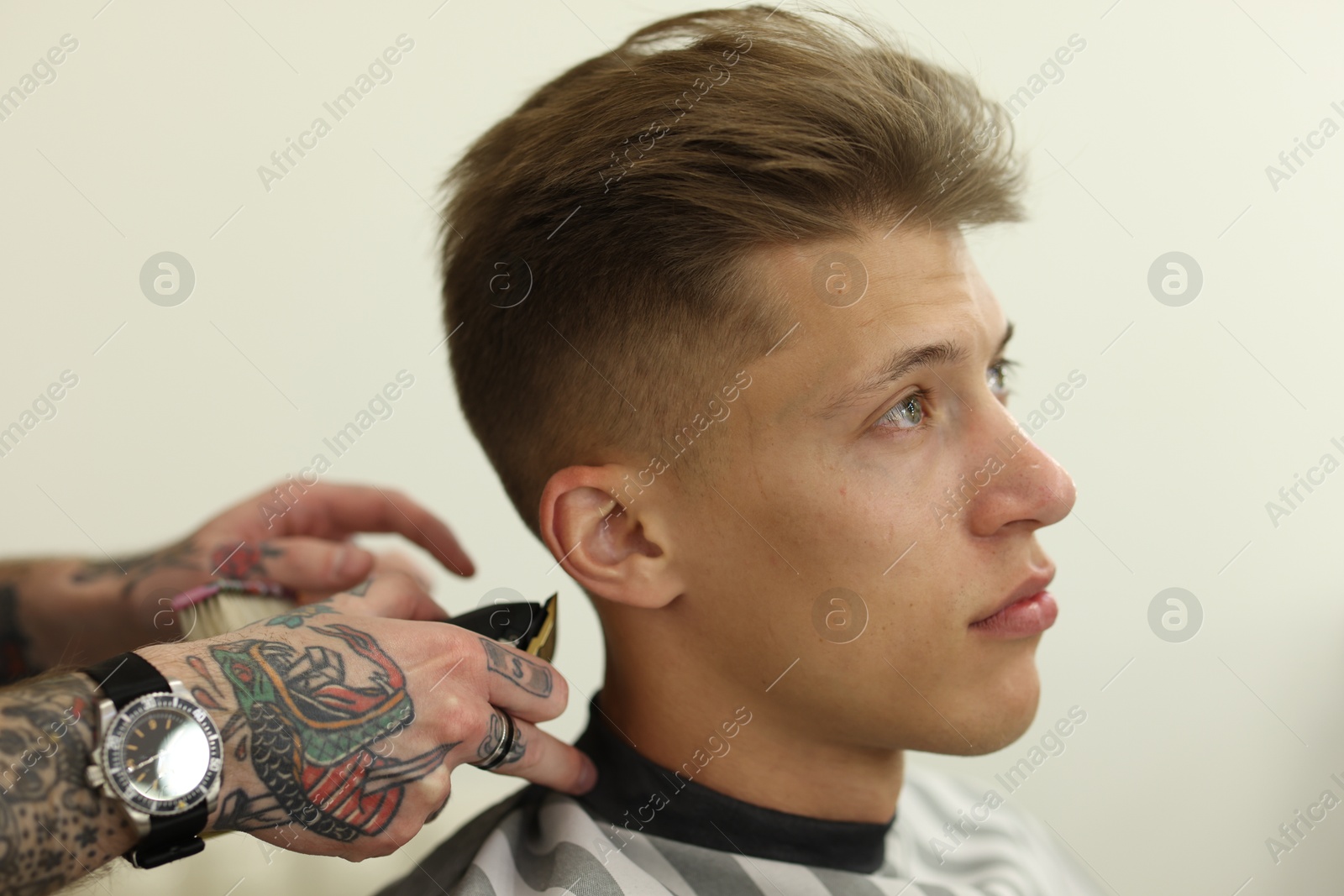 Professional barber making stylish haircut in barbershop, closeup Photo of Professional barber making stylish haircut in barbershop, closeup