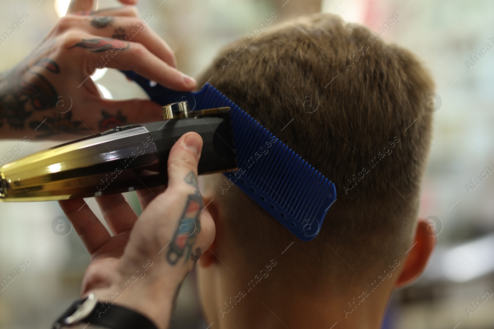 Professional barber making stylish haircut in barbershop, closeup Photo of Professional barber making stylish haircut in barbershop, closeup