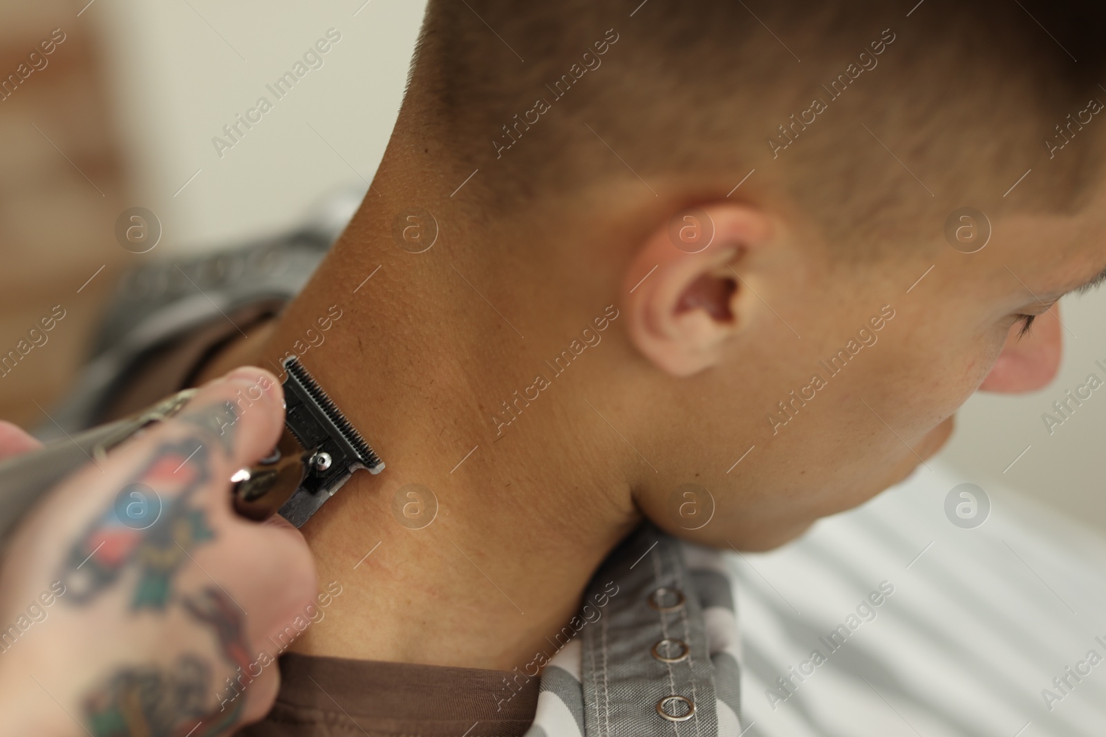 Professional barber making stylish haircut in barbershop, closeup Photo of Professional barber making stylish haircut in barbershop, closeup