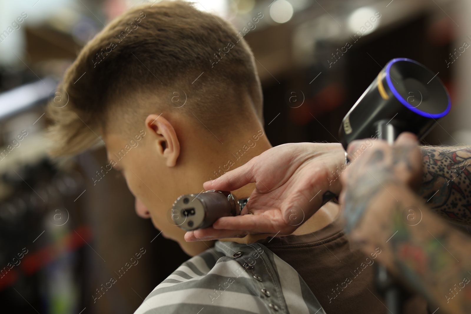 Professional barber making stylish haircut in barbershop, closeup Photo of Professional barber making stylish haircut in barbershop, closeup