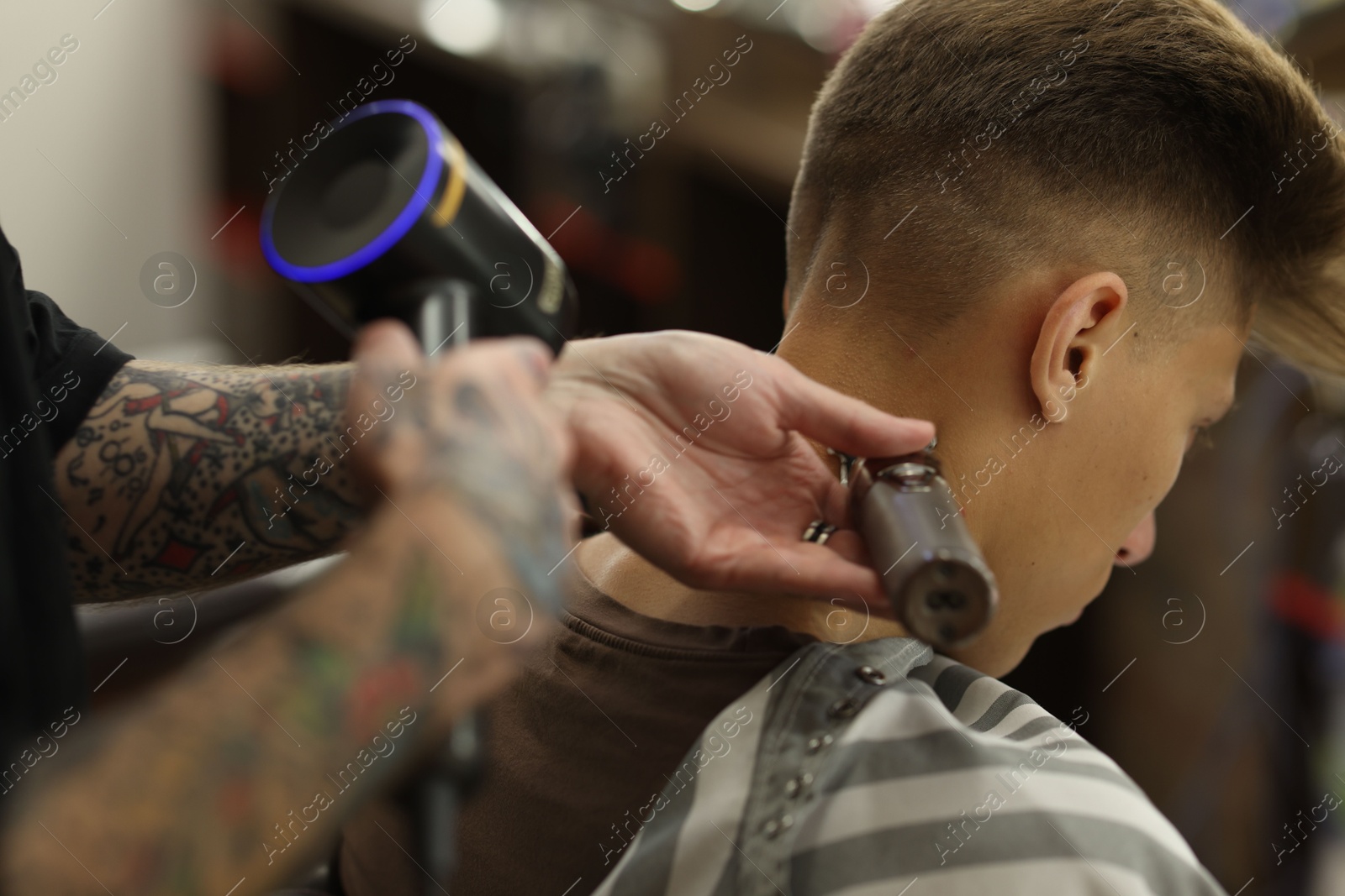 Professional barber making stylish haircut in barbershop, closeup Photo of Professional barber making stylish haircut in barbershop, closeup